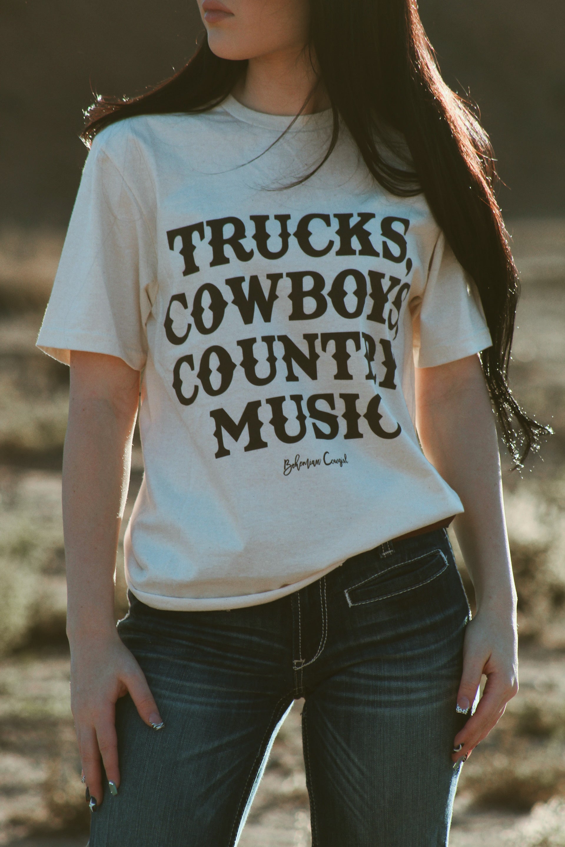 Bohemian cowgirl graphic tee with trucks cowboys country music lettering worn with denim