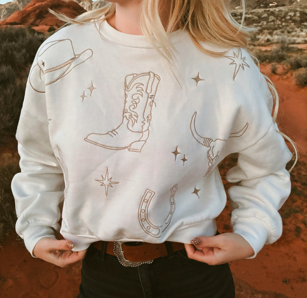 Western embroidered sweatshirt with cowgirl boots, horseshoe, longhorn skull, and star details
